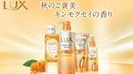 オレンジ色のキンモクセイの花を背景にした、ゴールド調デザインのLUX バスグロウ シャンプーボトル