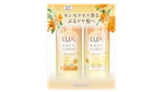 明るい背景に配置された、オレンジ色の花柄デザインのLUX バスグロウ キンモクセイ シャンプー&トリートメントボトル